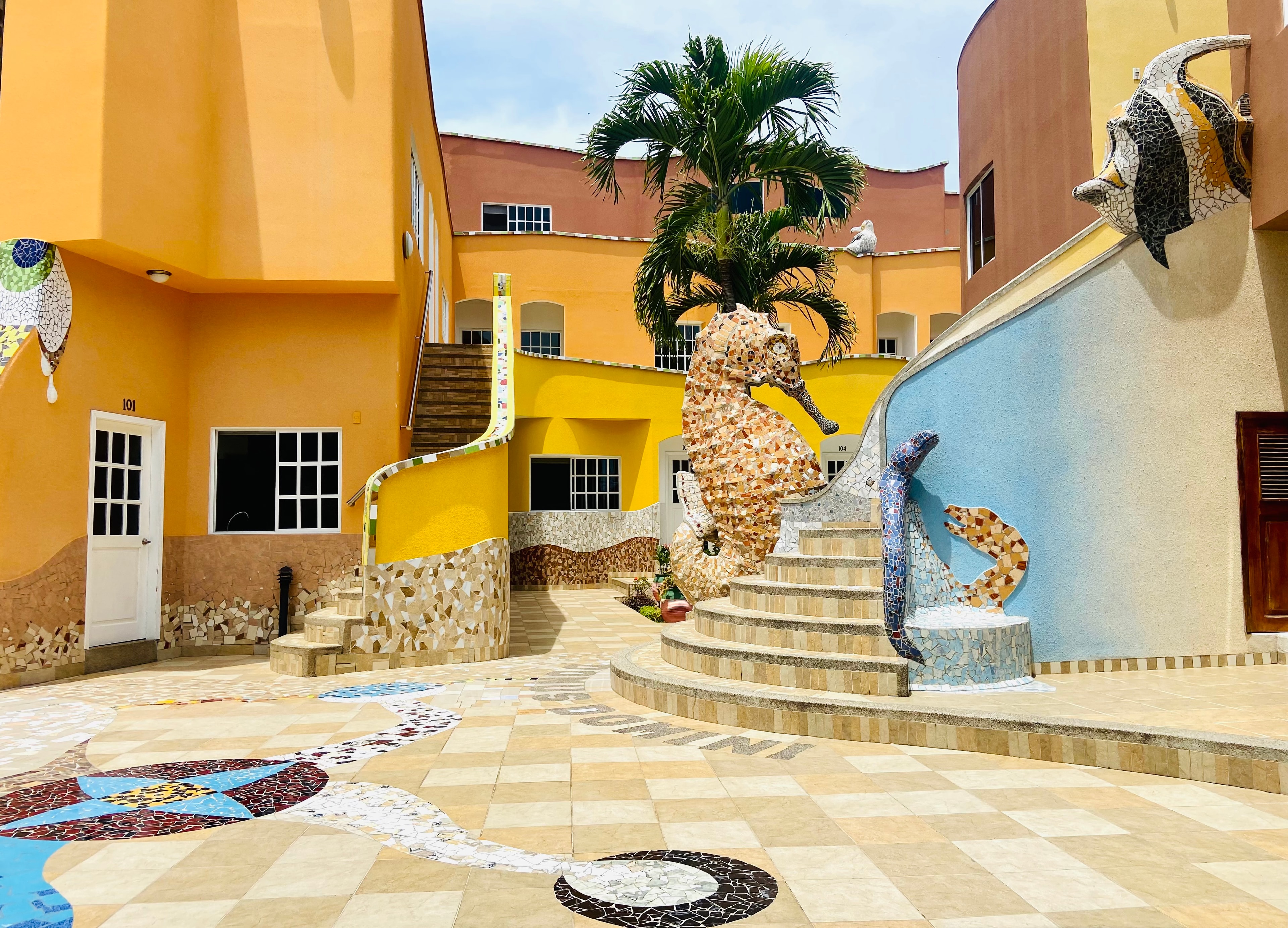 Katarma's vibrant mosaic courtyard with seahorse sculpture and tropical palms